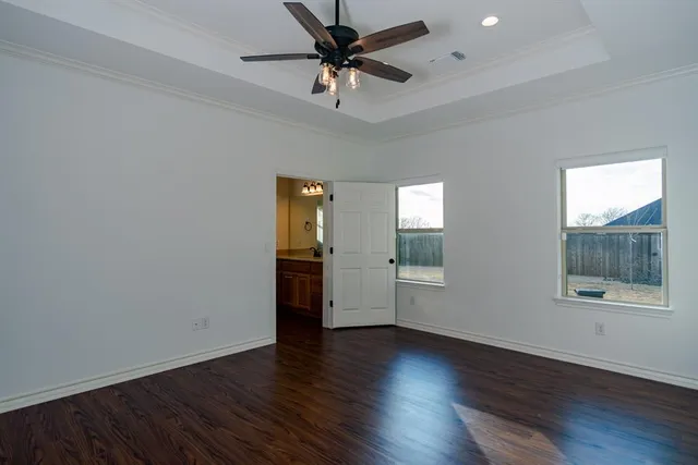 a view of a room with wooden floor and a ceiling fan
