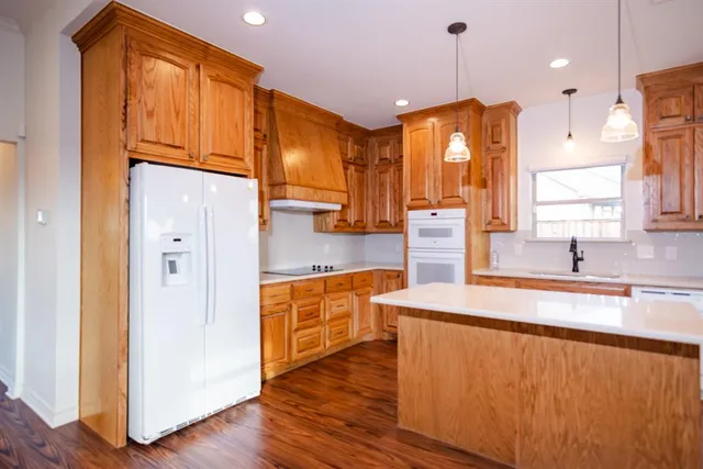 a kitchen that has a sink a stove and a wooden floor