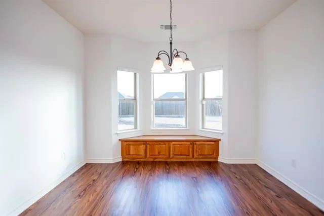 a large kitchen with a wooden floor and outdoor space