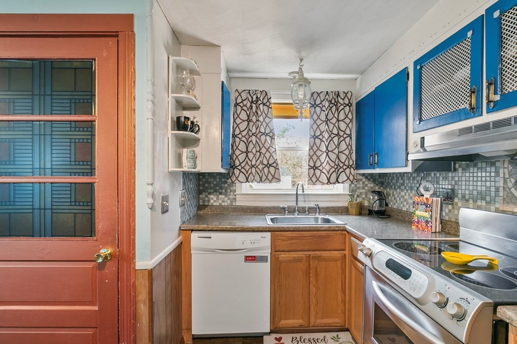 90 Newhouse Street Springfield, MA 01118 - Photo 12 of 36 a kitchen with a sink and wooden cabinets