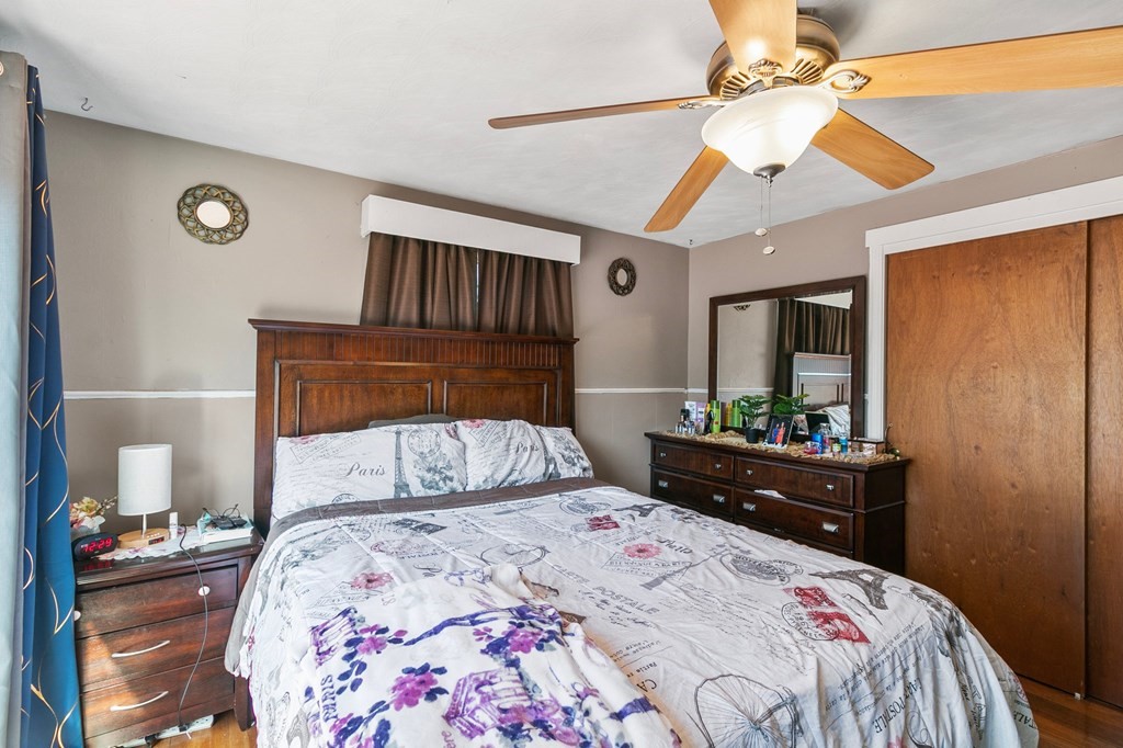 90 Newhouse Street Springfield, MA 01118 - Photo 21 of 36 a bedroom with a bed and wooden floor