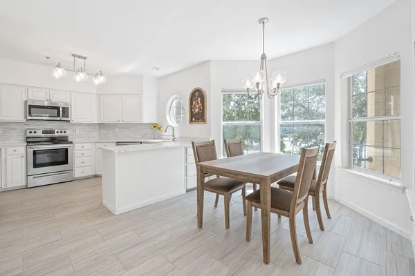 a dining room with furniture a chandelier and wooden floor