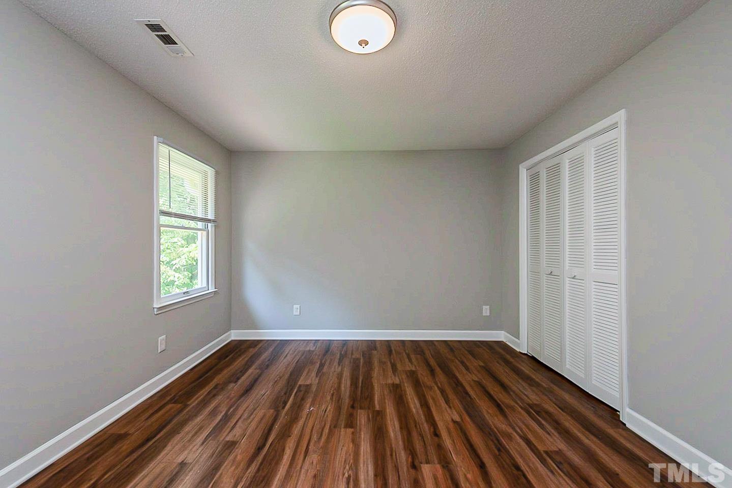 4714 Highgate Drive Durham, NC 27713 - Photo 15 of 22 an empty room with wooden floor and windows
