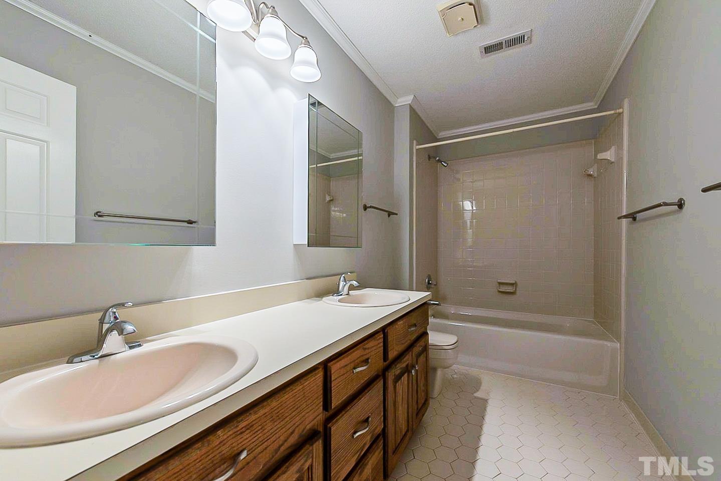 4714 Highgate Drive Durham, NC 27713 - Photo 18 of 22 a bathroom with a sink double vanity granite tub shower and a mirror