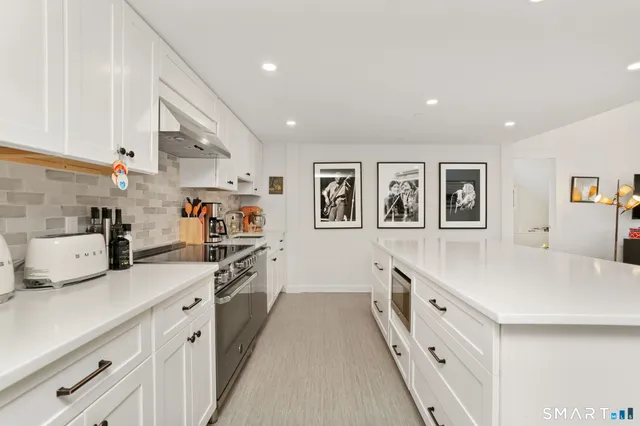 a kitchen with stainless steel appliances a sink stove and cabinets