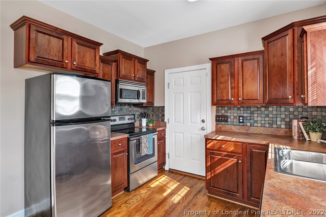 31 Reece Drive Sanford, NC 27332 - Photo 12 of 36 a kitchen with stainless steel appliances granite countertop a stove a sink and a microwave