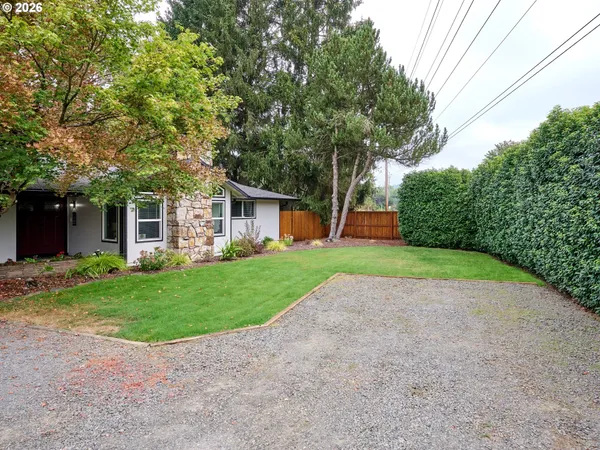 a front view of house with garden and trees