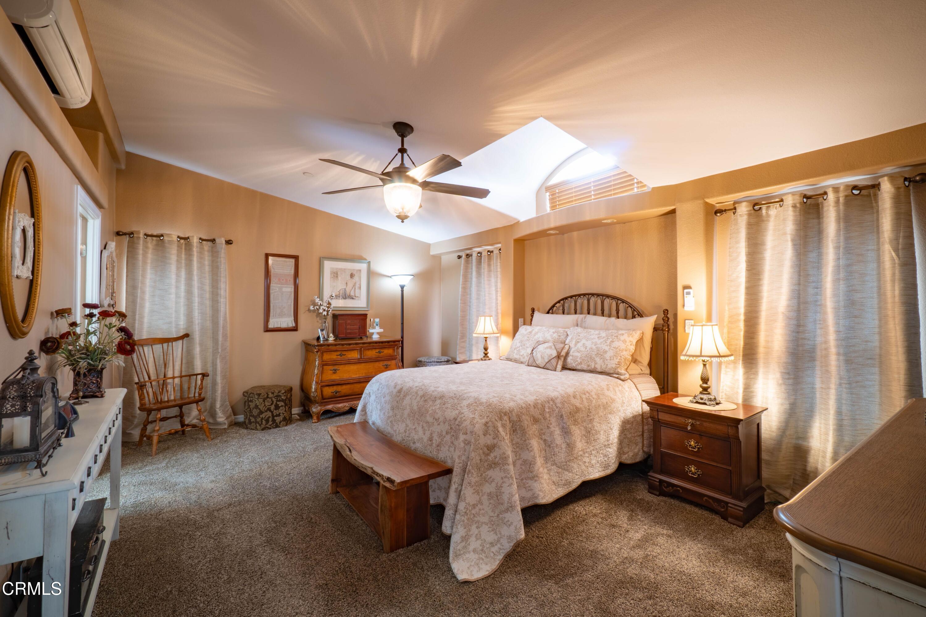 3760 Howe Road Fillmore, CA 93015 - Photo 15 of 32 a spacious bedroom with a bed a chandelier and a large window