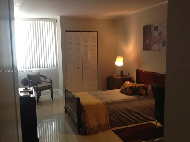 a bedroom with a bed and a lamp next to a window