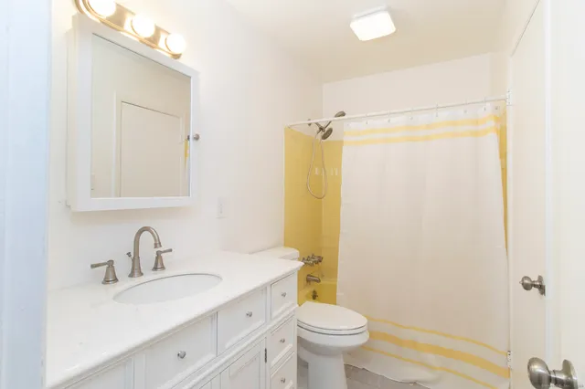 a bathroom with a sink toilet a mirror and shower