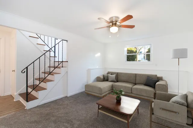 a living room with furniture and a ceiling fan