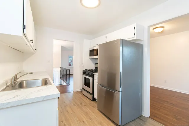 a kitchen with a refrigerator sink and wooden floor