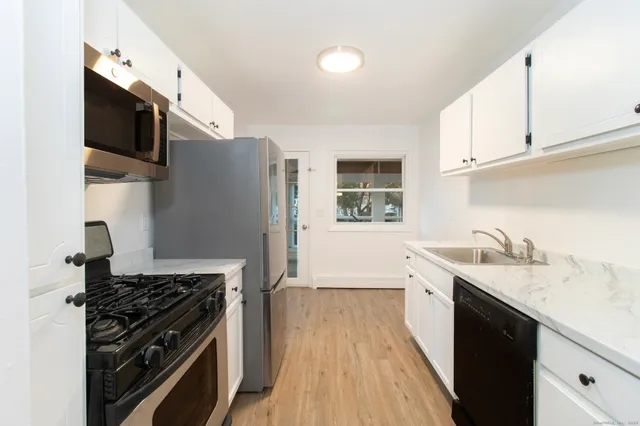 a kitchen with stainless steel appliances granite countertop a sink stove and refrigerator