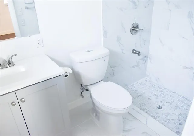 a white toilet sitting next to a bathroom sink