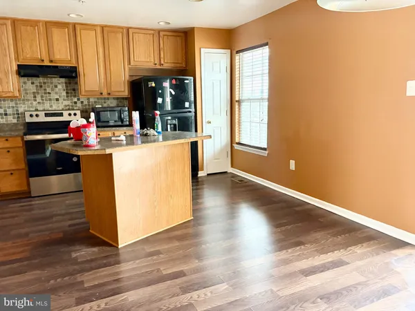 a kitchen with counter top space and wooden floor