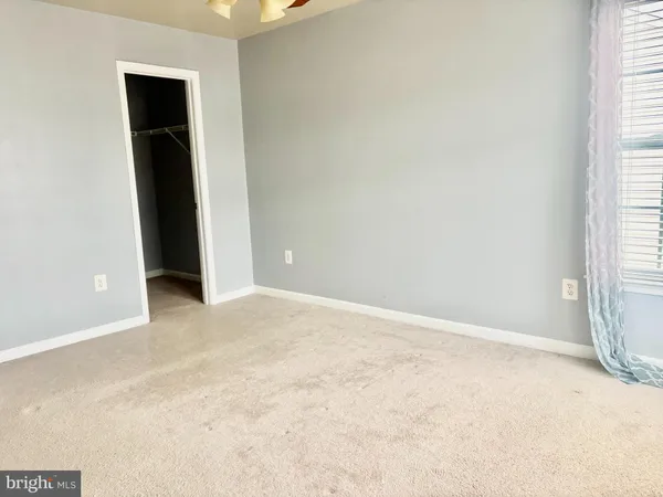 an empty room with closet and windows