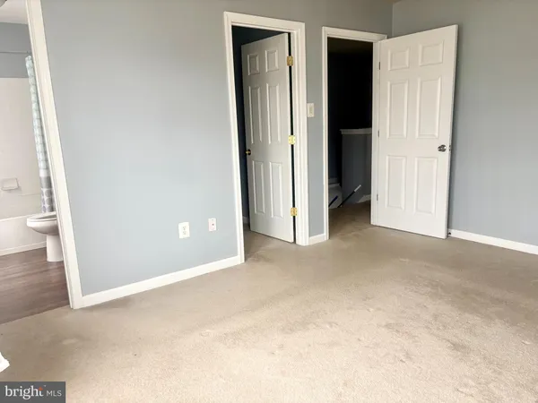 an empty room with closet and a bathroom