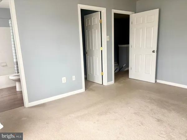 an empty room with closet and a bathroom