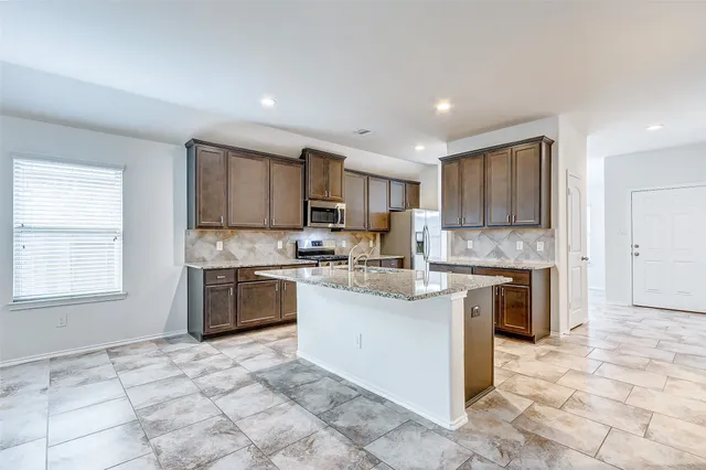 a kitchen with a stove a sink and a refrigerator