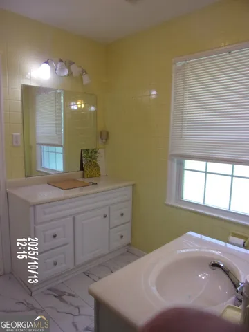 a bathroom with a granite countertop toilet sink and mirror