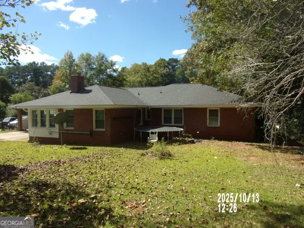 a view of a house with backyard and sitting area