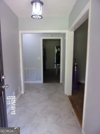 a view of a hallway with wooden floor and a bathroom
