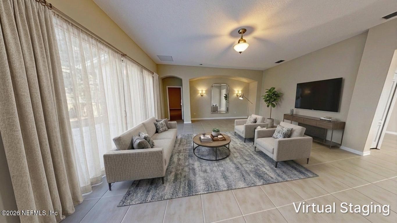 14454 Millhopper Road Jacksonville, FL 32258 - Photo 15 of 44 a living room with furniture and a flat screen tv