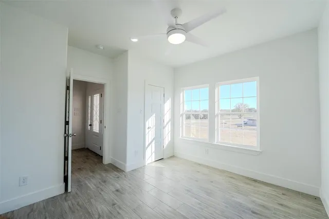 an empty room with wooden floor and window