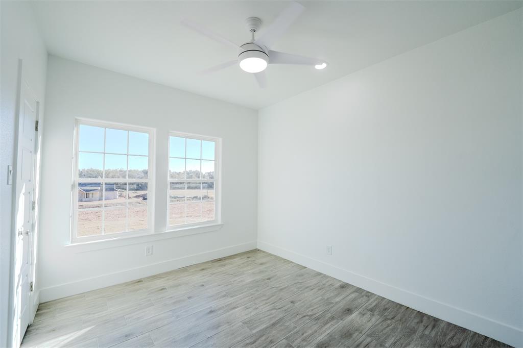 200 Kilkenny Road Poolville, TX 76487 - Photo 12 of 36 an empty room with wooden floor and windows