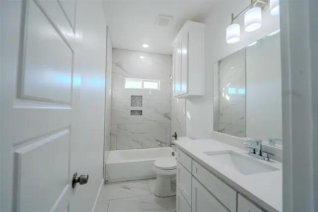 a bathroom with a double vanity sink toilet and shower