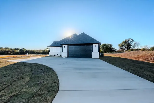 a front view of a house with a yard and ocean view