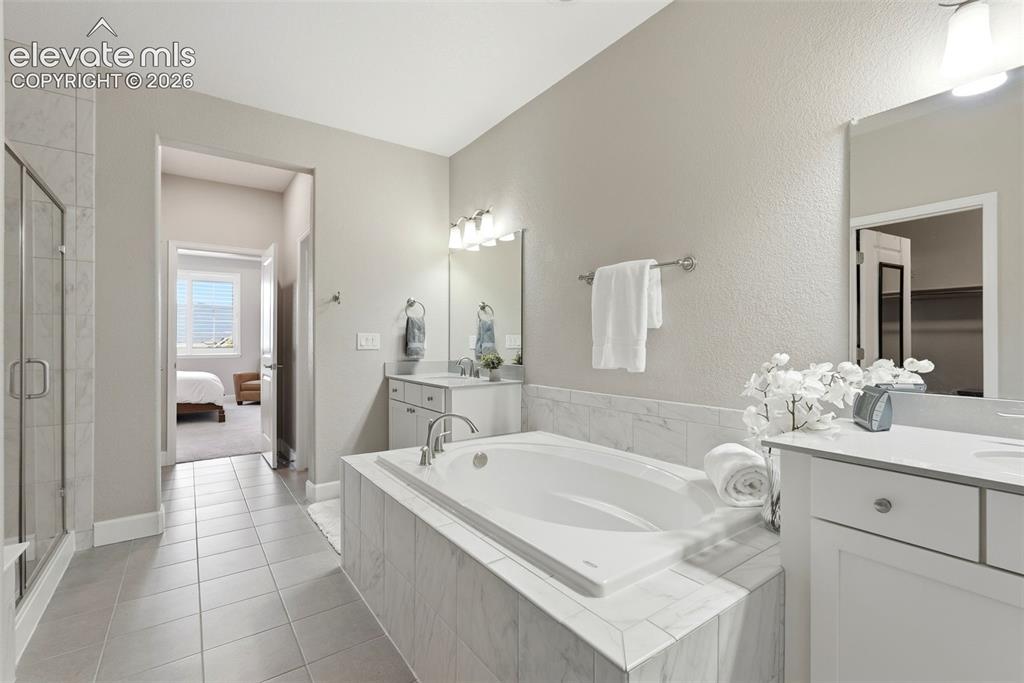 1394 Promontory Bluff View Colorado Springs, CO 80921 - Photo 28 of 47 a bathroom with a tub sink and mirror