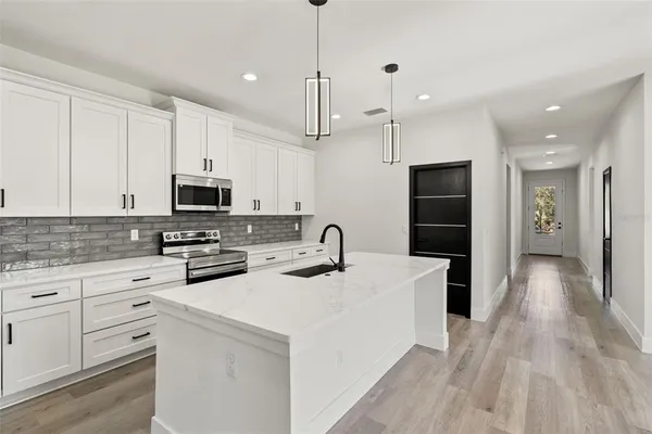 a kitchen with a sink stainless steel appliances and white cabinets