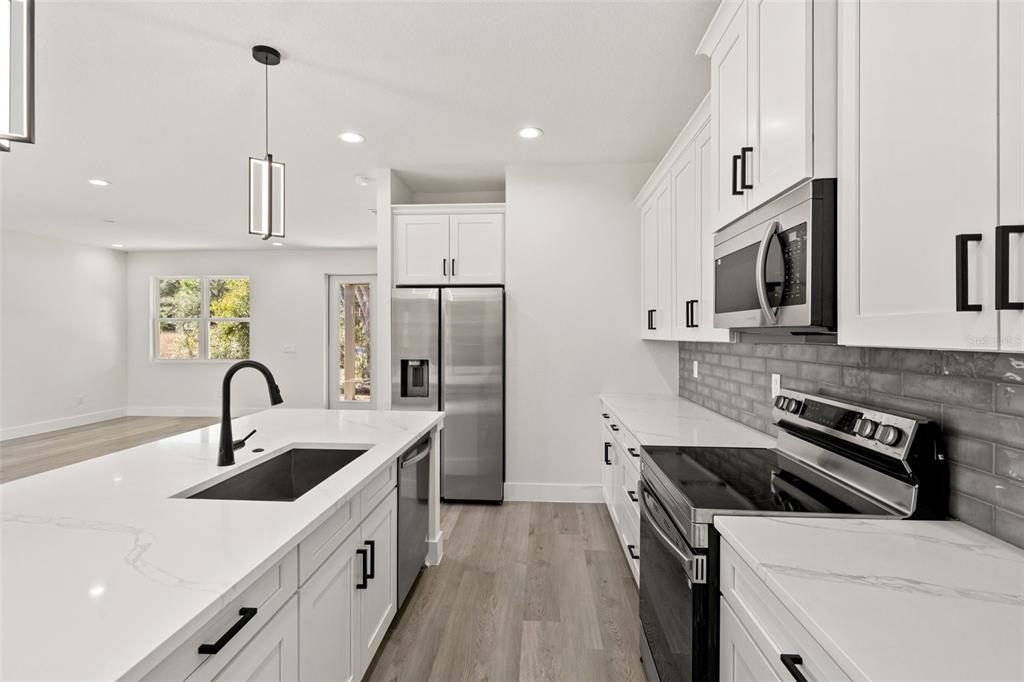 11810 North Providence Way Citrus Springs, FL 34433 - Photo 13 of 53 a kitchen with a sink stainless steel appliances and white cabinets