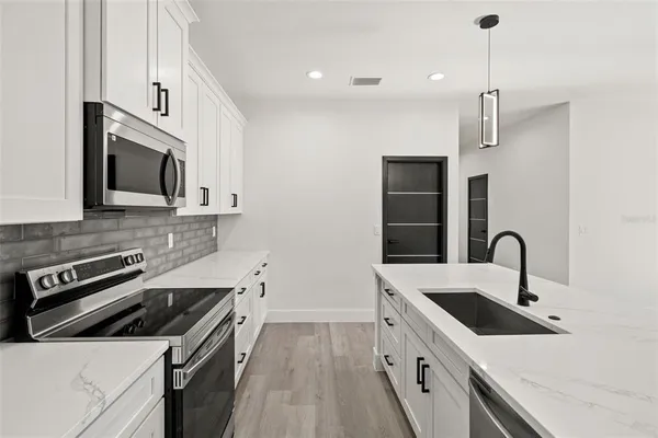 a kitchen with stainless steel appliances white cabinets and a sink
