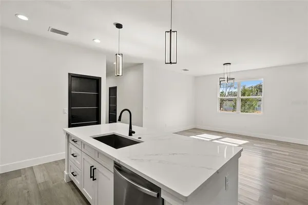 a kitchen with stainless steel appliances granite countertop a sink a stove and a refrigerator