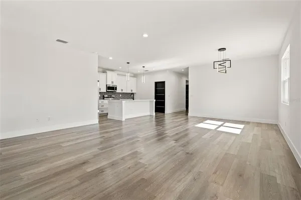 a view of kitchen with granite countertop cabinets and refrigerator