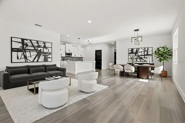 a living room with furniture a window and wooden floor