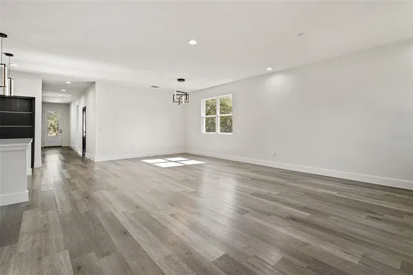 a view of a kitchen with wooden floor and a window