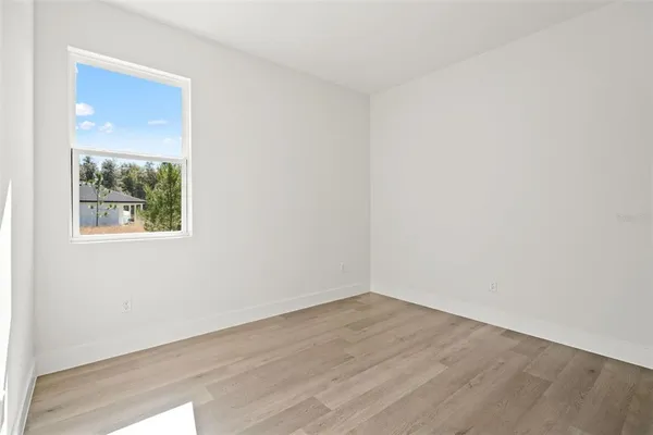 a room with a closet a window and wooden floor
