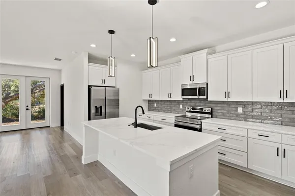 a view of a kitchen with a sink and wooden floor