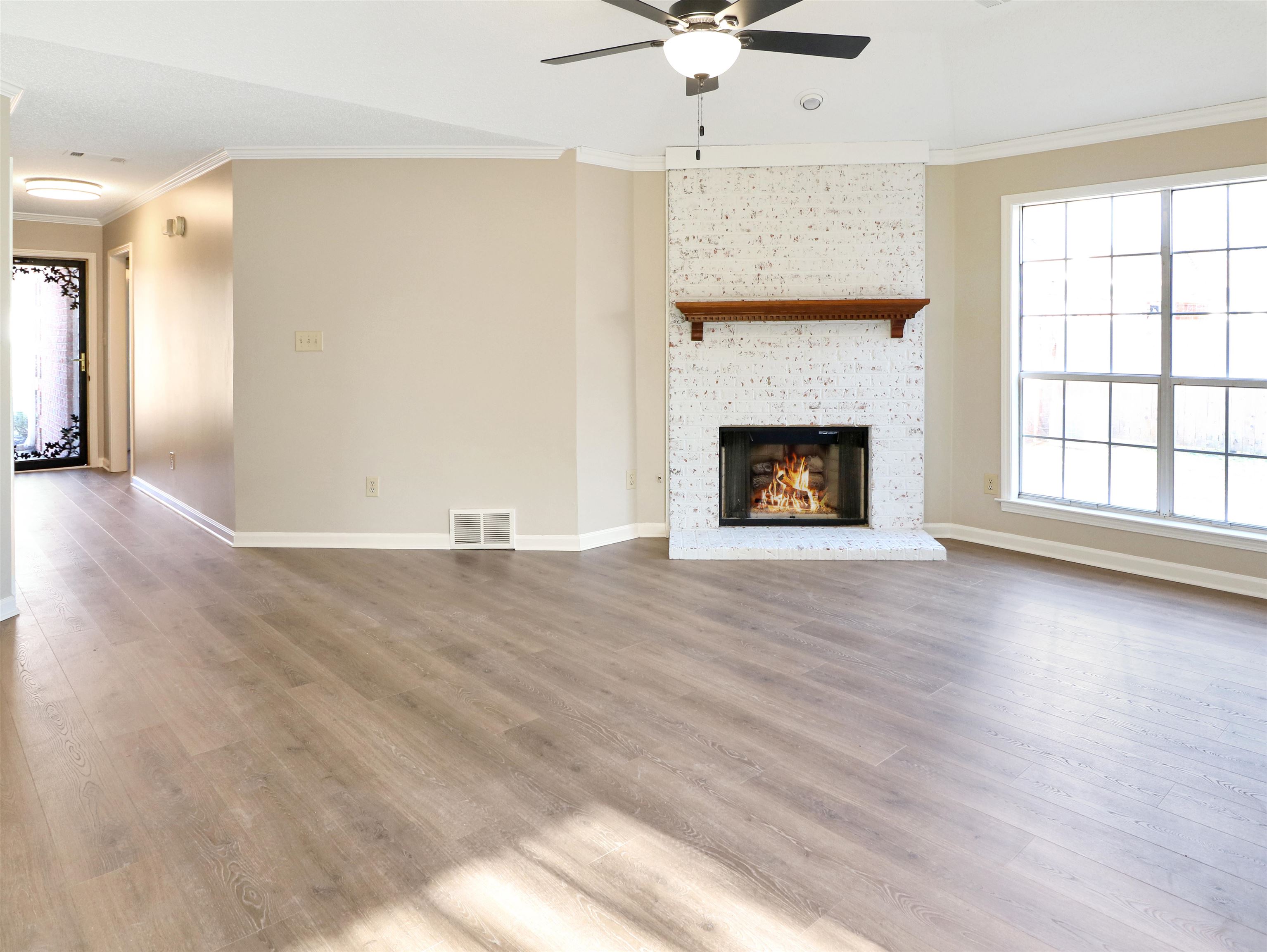 2321 Valley Edge Cove Memphis, TN 38016 - Photo 4 of 18 an empty room with wooden floor fireplace and windows