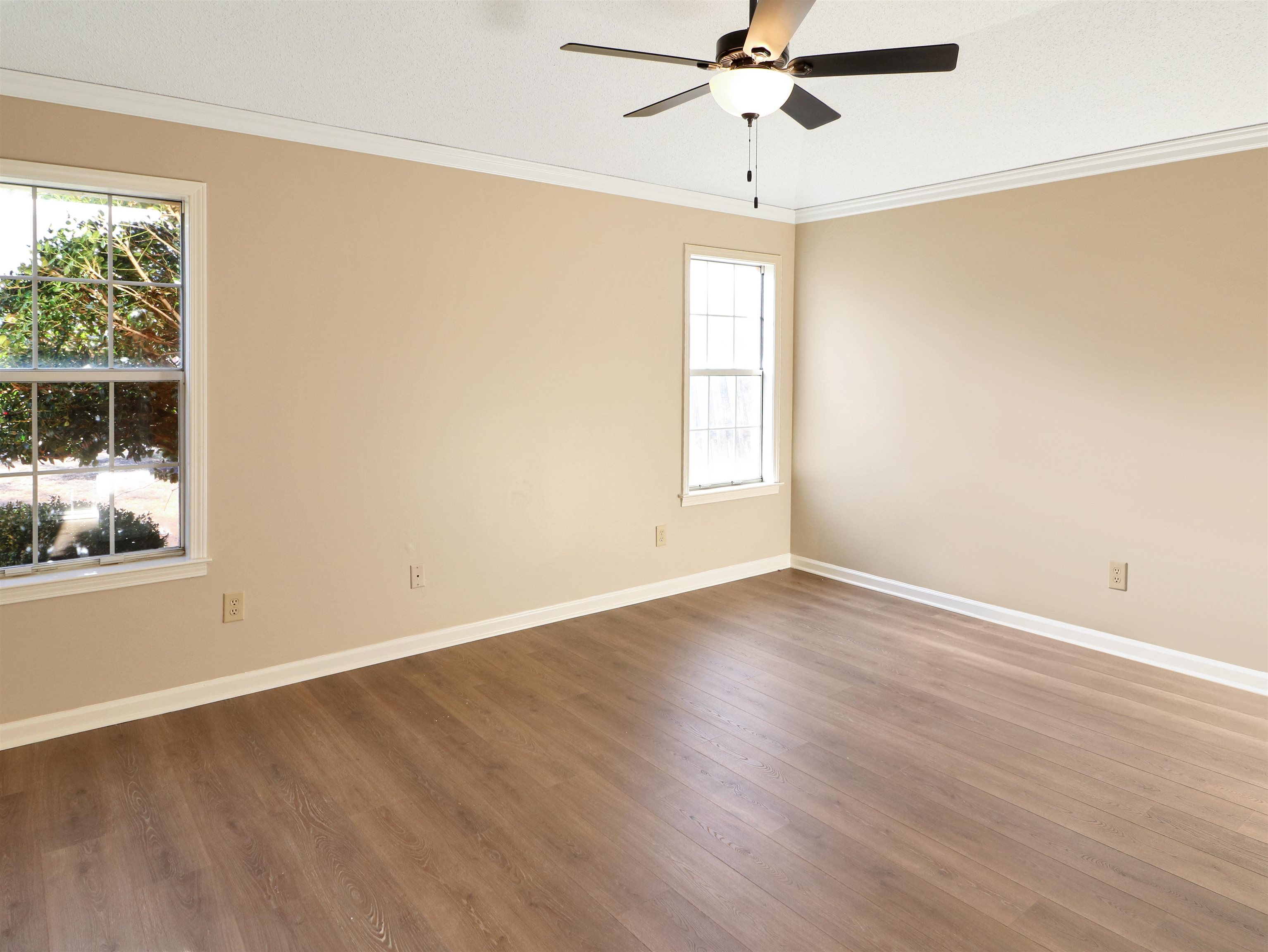 2321 Valley Edge Cove Memphis, TN 38016 - Photo 9 of 18 an empty room with wooden floor fan and windows