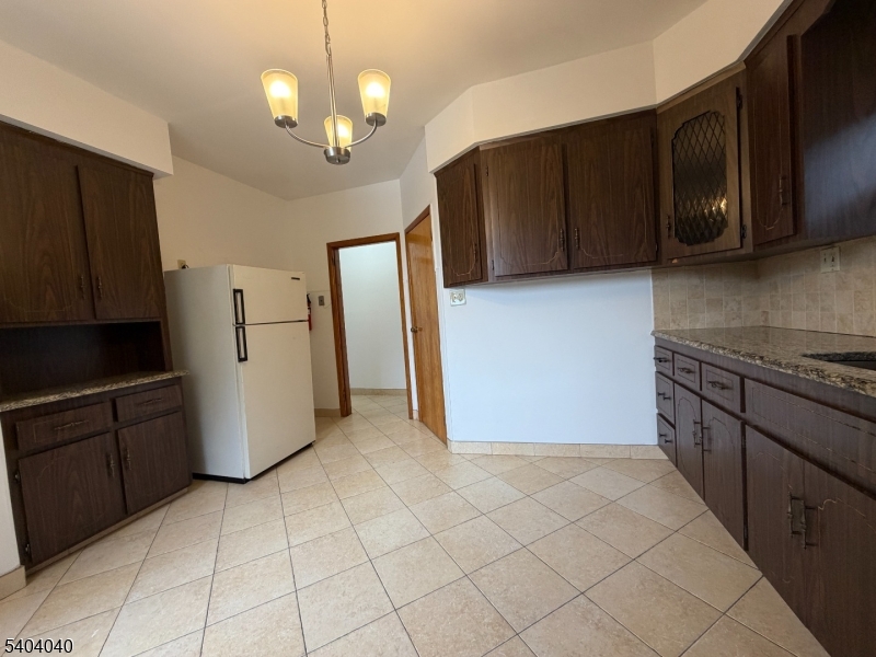 106 Glenridge Avenue, Unit 2 Glen Ridge, NJ 07028 - Photo 2 of 9 a kitchen with a refrigerator a stove top oven cabinets and a counter top space