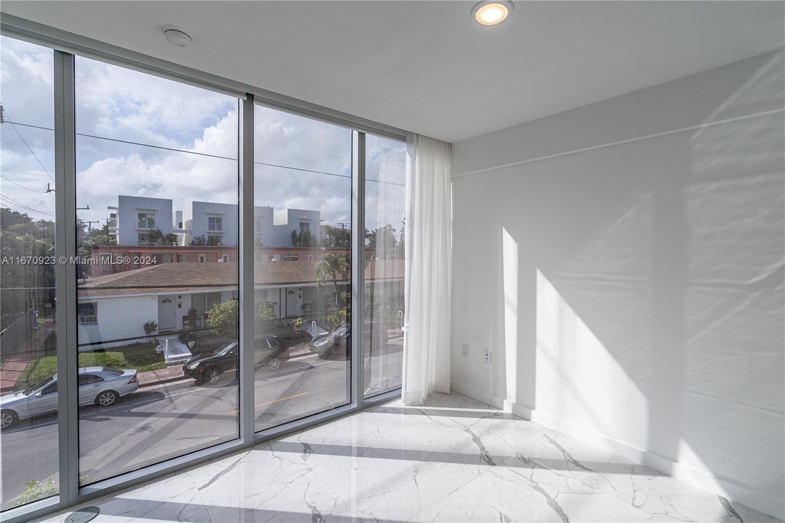 8425 Crespi Boulevard, Unit TH4 Miami Beach, FL 33141 - Photo 15 of 26 a view of a glass door and window