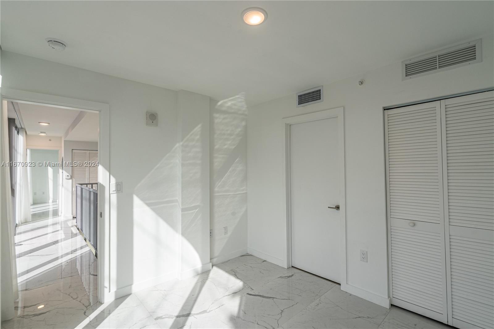 8425 Crespi Boulevard, Unit TH4 Miami Beach, FL 33141 - Photo 21 of 26 a view of a hallway with a white walls