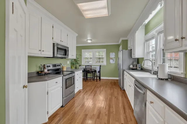 a kitchen with kitchen island granite countertop lots of counter top space and stainless steel appliances