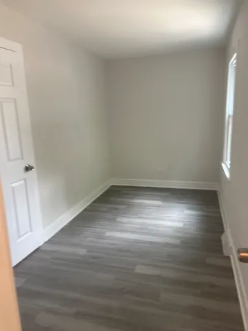 a view of room with window and wooden floor