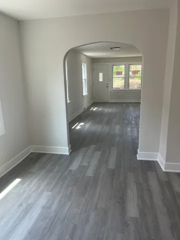 an empty room with wooden floor and mirror