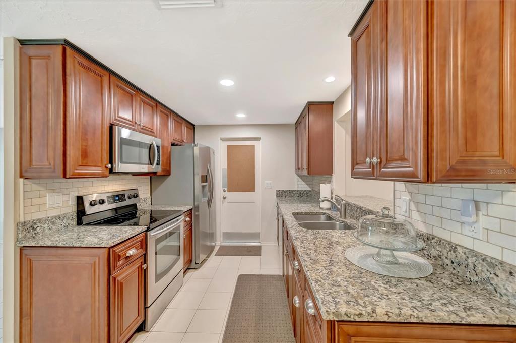 4478 Coco Ridge Circle Sarasota, FL 34233 - Photo 16 of 85 a kitchen with granite countertop kitchen island stainless steel appliances a sink stove and cabinets